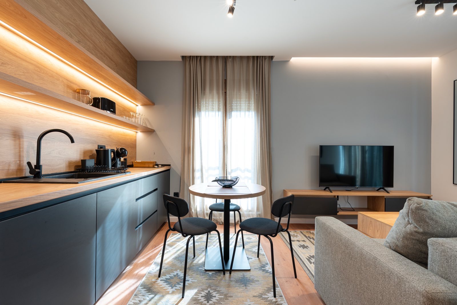 Kitchen with lit oak shelving and dining table